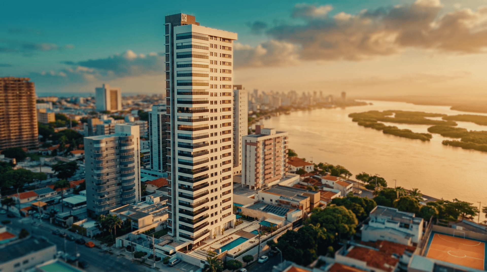 Vista aérea do Edifício Miguel Carrilho ao pôr do sol com o Rio Potengi ao fundo em Natal RN
